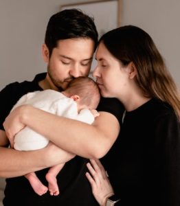 imagen de unos padres sujetando a su bebé recién nacido